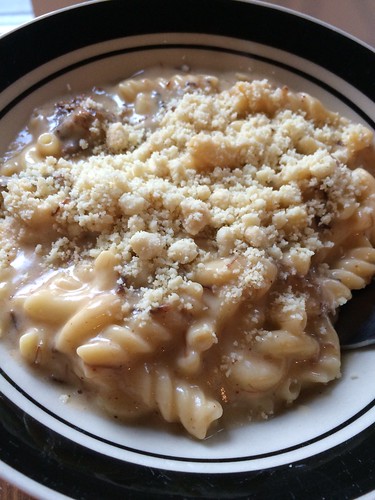 A close up of a bowl of pasta in cheese sauce, contanint both elbow and spiral pastas.