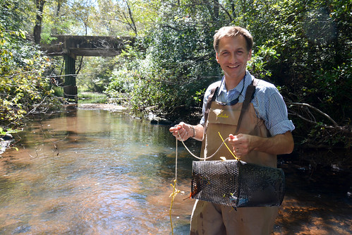 Brian Helms standing in a stream with a crayfish trap