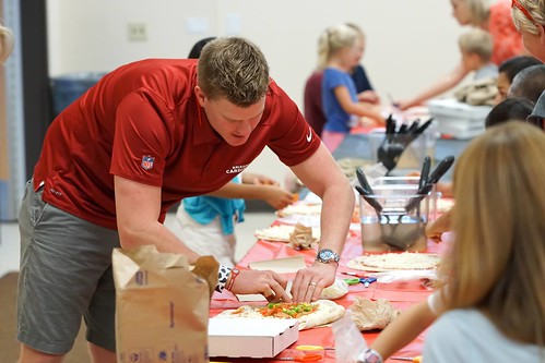 Arizona Cardinals football player Drew Butler making pizza with kids at the Ken "Chief" Hill Learning Academy of the Chandler Unified School District in Arizona