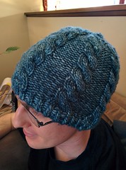 A blue knit hat with cables