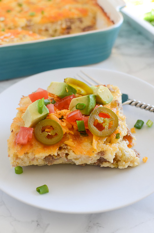 Loaded Grits Casserole - full of turkey sausage, sharp cheddar, green chiles and topped with avocado, tomatoes, green onions, and more!