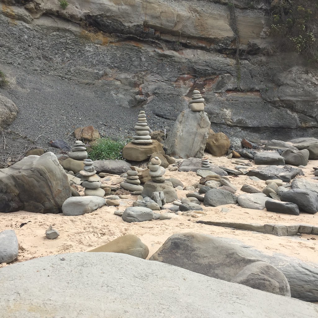 a series of stacks of rocks on the beach in inverloch