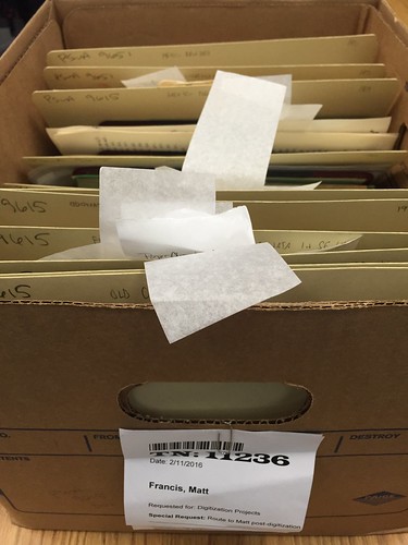 A box of files of field notes flagged for digitization.