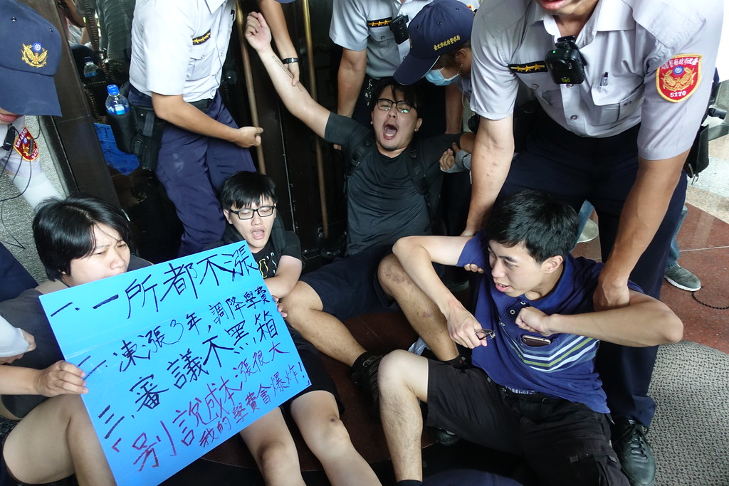 反漲學費的學生翻過教育部鐵門，衝到門口前抗議遭警方壓制。（攝影：張智琦）