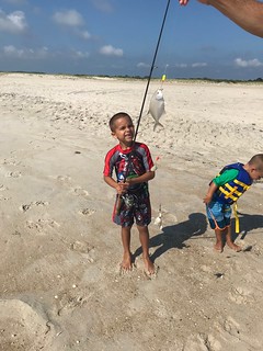 Photo of Boy with his catch of a pompano on the beach