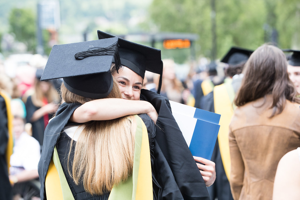 graduates hugging eachother