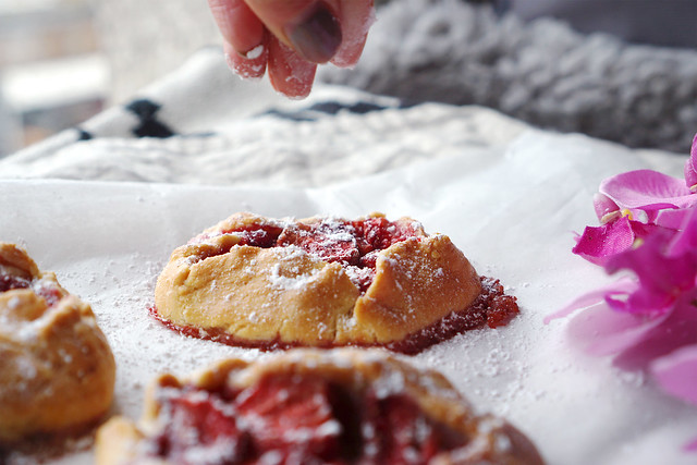 Mini gluten free strawberry rustic pies with a sprinkle of icing sugar.
