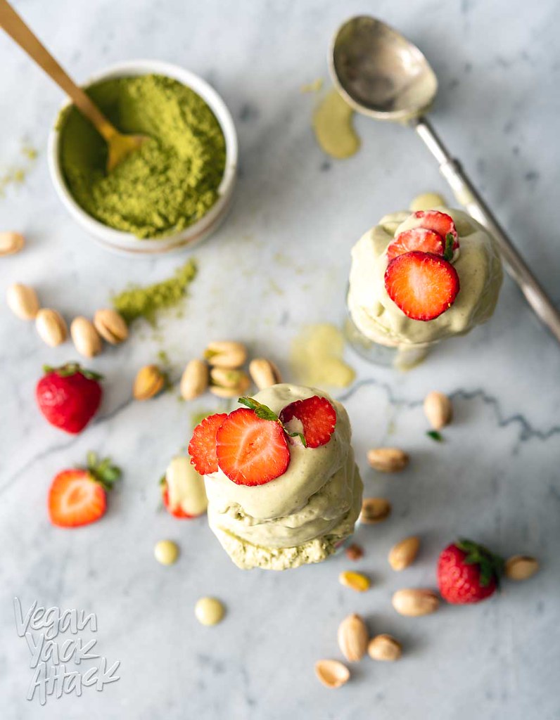 Image of two cones of pistachio matcha ice cream on a marble counter top