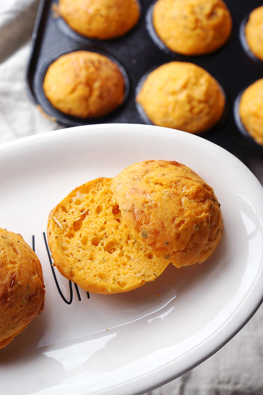 Gluten free mini cheese muffin rolls with a hint of garlic, tomato and oregano | sliced in half, showing their light and airy texture