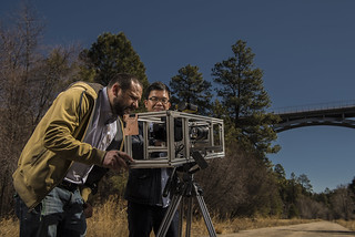 Yongchao Yang, left, and David Mascareñas make adjustments to the video camera used in their video-based technology to measure and assess the response of structures to dynamic loads.