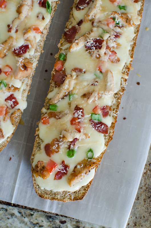 Chicken Alfredo French Bread Pizza - easy weeknight meal the whole family will love! French bread layered with alfredo sauce, chicken, bacon, green onions, tomatoes, and 2 cheeses. 