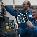 Paul Graham and Robert Merl work on the Low-Cost, Radiation-Hardened Single-Board Computer for Command and Data Handling both wearing blue lab coats