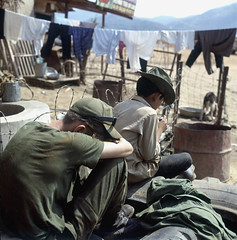 U.S. military (support troops) in Vietnam, 1967. Washed clothes on a clothesline and rolled out barbed wire of a refugee camp