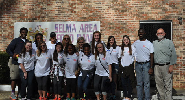 A group of Auburn students and their advisor stand in front of the Selma Area Food Bank building.