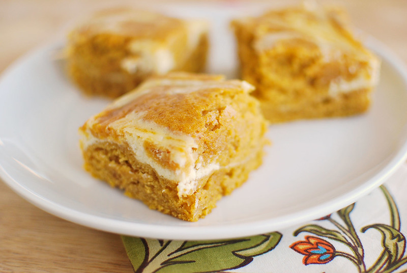 Pumpkin Roll Bars - everything you love about a pumpkin roll without all the work! Pumpkin cake with cream cheese swirl!