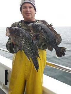Photo of Man holding two black sea bass
