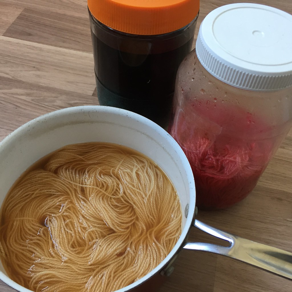 a pot and jars containing yarn dyeing away