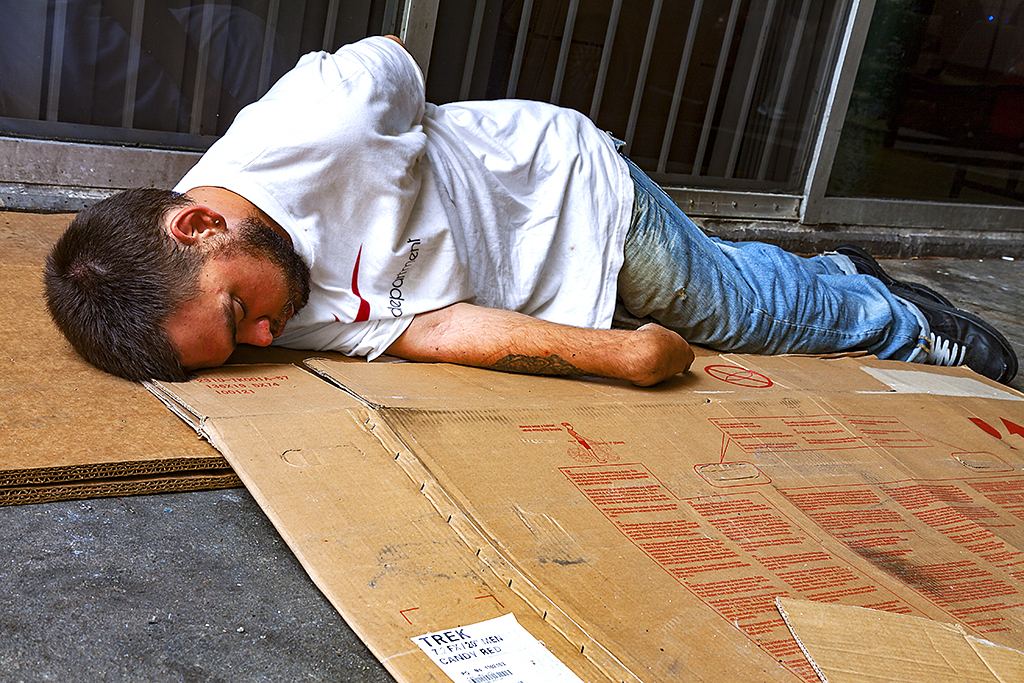 Man-in-white-T-shirt,-lying-on-carboard--Chinatown