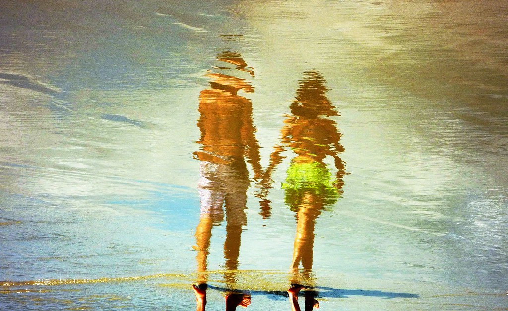 Water Art A young couple walk hand in hand on a Brazilian