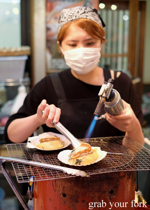 Blowtorching steamed scallops at Omicho Market, Kanazawa, Japan