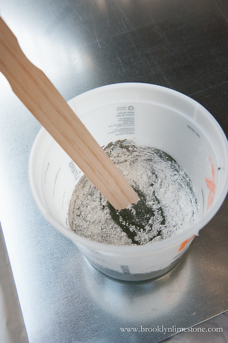 Outdoor Chalkboard paint being mixed using a stir stick in paint with unsanded grout mixed in
