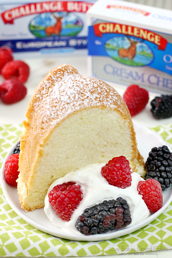 Old-Fashioned Cream Cheese Pound Cake on a plate with fresh berries and a package of Challenge Cream Cheese.