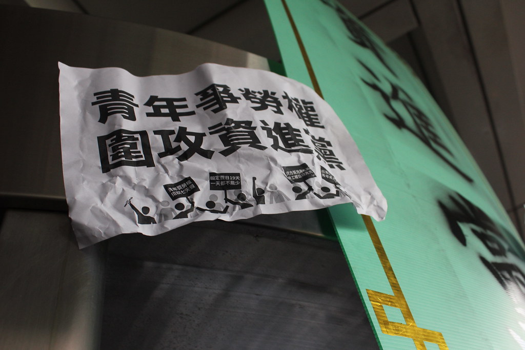 抗議群眾將寫有「青年爭勞權，圍攻資進黨」的標語以及「資進黨」匾額貼在民進黨部外牆。（攝影：高若想）