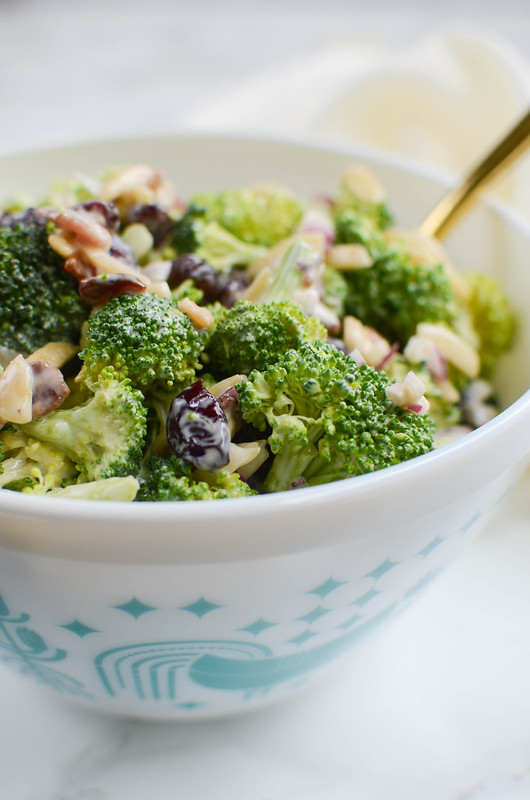 Cranberry Almond Broccoli Salad - a lightened up version of the classic! Broccoli, crumbled bacon, almonds, red onion, and dried cranberries in a creamy, tangy dressing. Perfect side dish for a summer party or a holiday dinner!