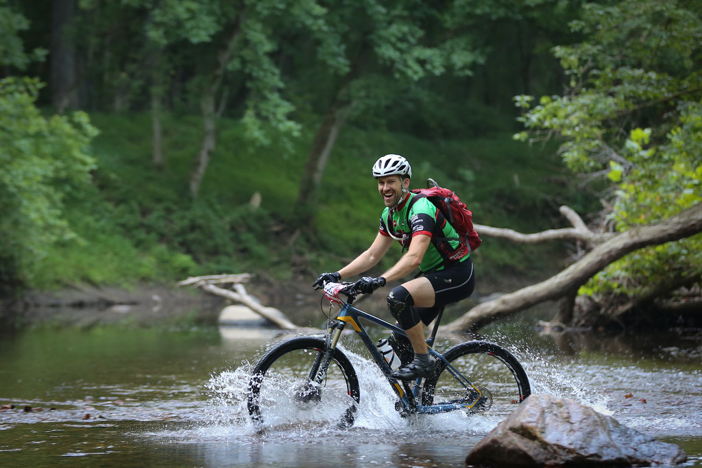 Photo of cyclist having fun in a stream, by James Corbett