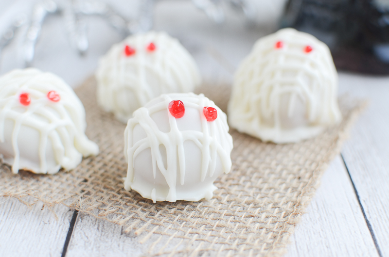 Mummy Oreo Truffles - a spooky twist on the classic Oreo Truffles. Use Pumpkin Spice Oreos and white almond bark to create these little mummies! These are the cutest treats to bring to Halloween parties!