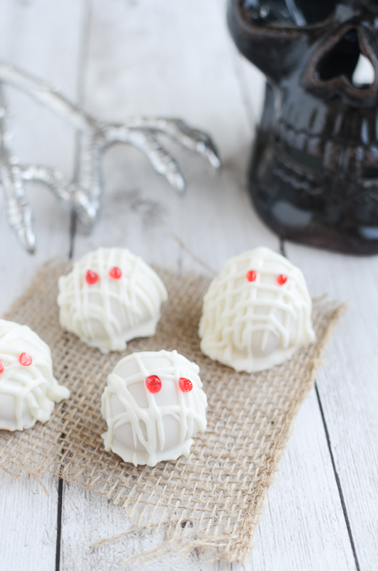 Mummy Oreo Truffles - a spooky twist on the classic Oreo Truffles. Use Pumpkin Spice Oreos and white almond bark to create these little mummies! These are the cutest treats to bring to Halloween parties!