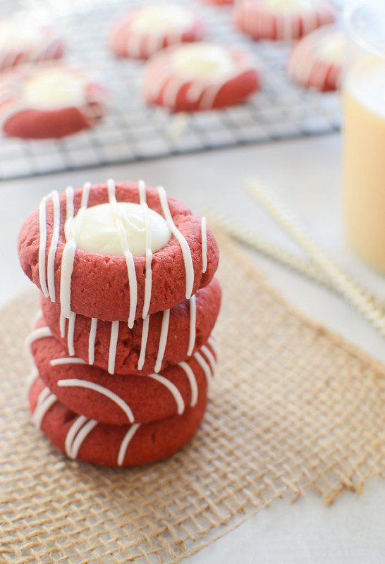 Red Velvet Peppermint Thumbprints will be Santa's new favorite cookie! Red velvet peppermint dough filled and drizzled with white chocolate!