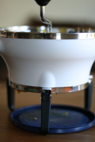 An OXO Good Grips Food Mill over a plastic lid.