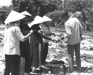 Women examining wire used to bind the hands of Tet Offensive victims.