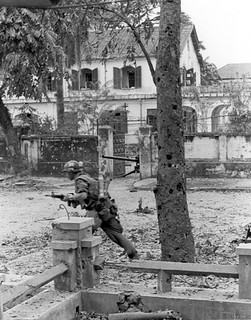 Under Fire -- A Leatherneck  moves out under intense enemy .50 caliber machine gun fire during heavy street fighting taking place in the old Imperial Capital of Hue.
