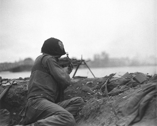 A U.S. Marine machine gunner fires on communists positions across the Perfume River in the imperial city of Hue