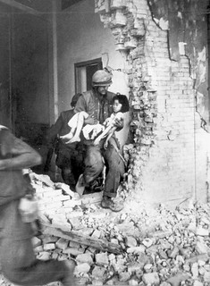 A US Marine carries a seriously wounded Vietnamese child from the ruins of a home in Hue.
