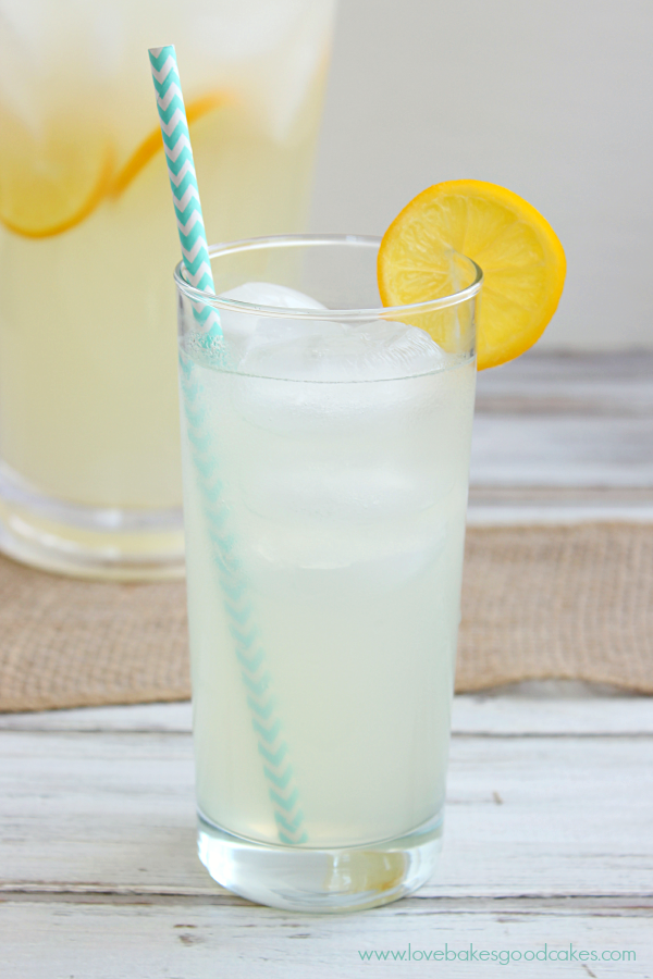 Perfect Lemonade in a glass with a lemon slice and a straw.