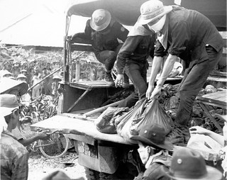 Hue - Volunteer Civil Defense workers unload some of the 136 bodies of VC hostages recently found along the sandy beaches south of Hue.
