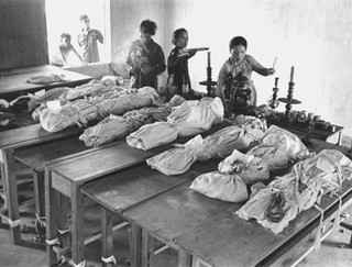 1971 Shrouded remains of Tet Offensive victims prepared for reburial.