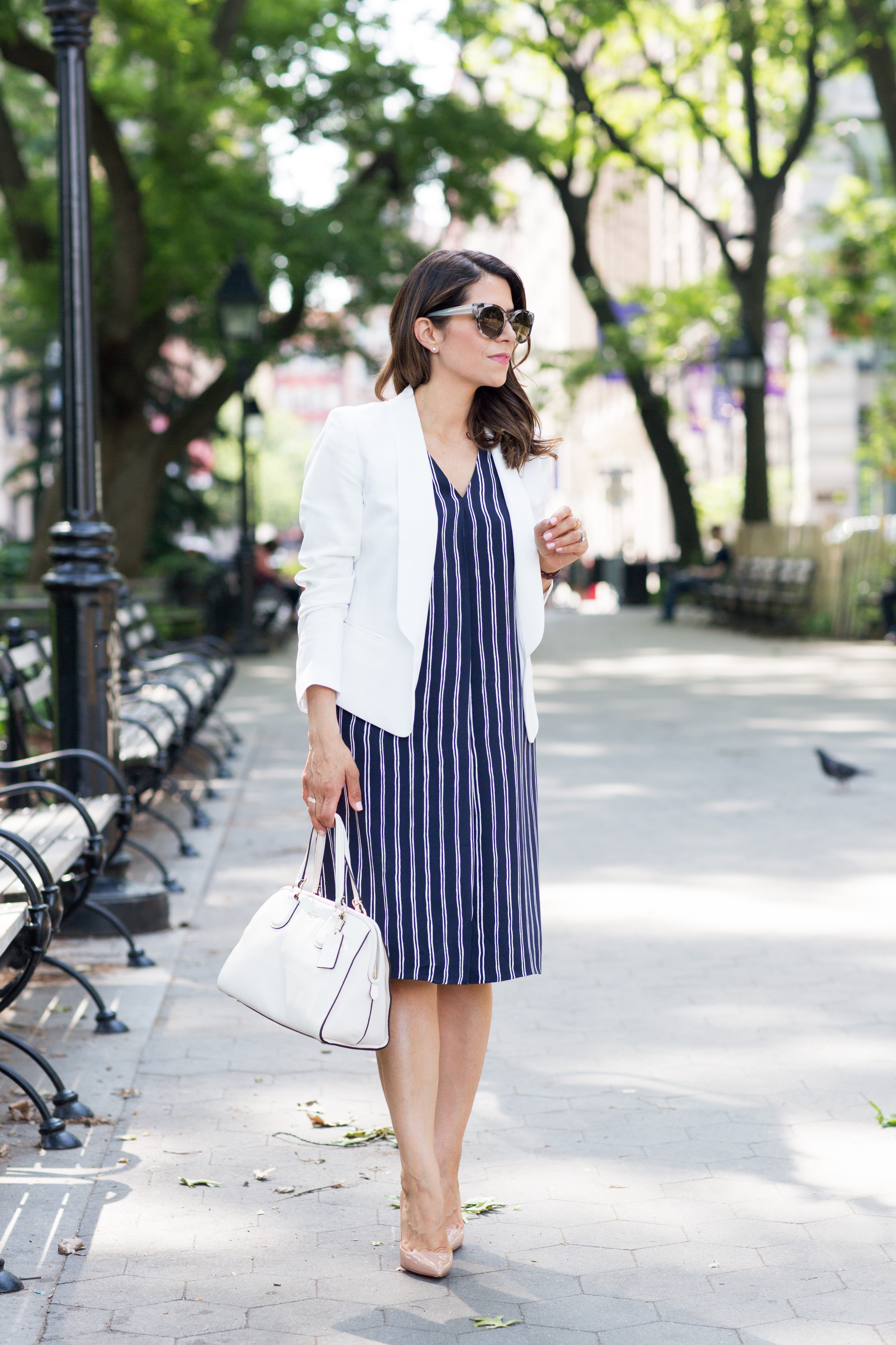 Wearing striped dress with white blazer and white bag in New York during summer on Corporate Catwalk