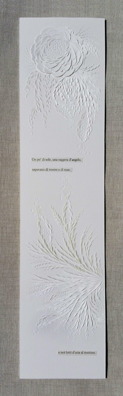 narrow, vertical, all-white paper carving on wall