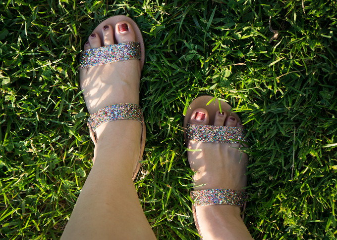 standing in the grass wearing ancient greek glitter clio sandals