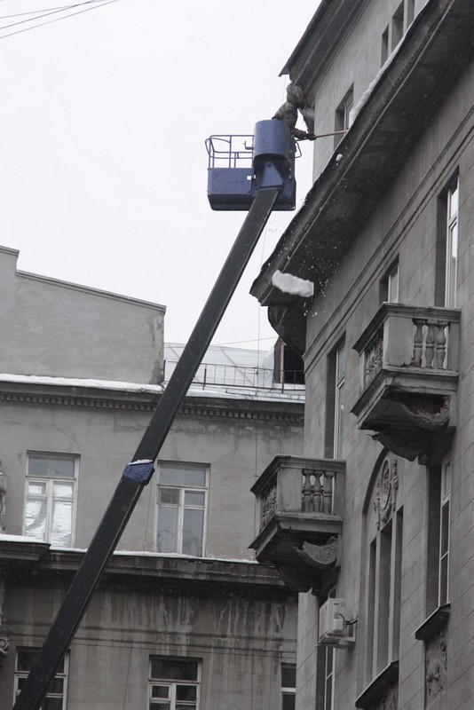 Clearing deadly icicles from the eaves of a Moscow apartment block