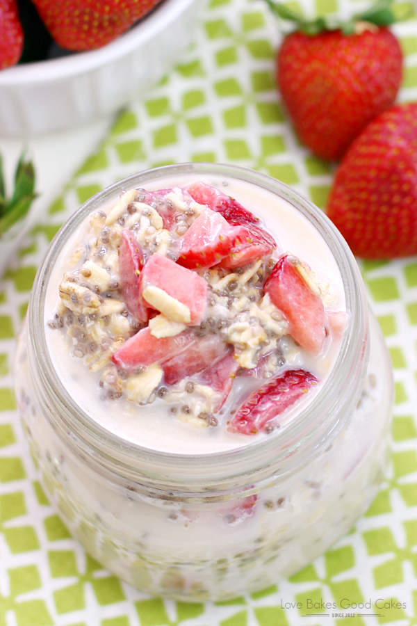 Strawberry Vanilla Overnight Oatmeal in a glass jar with fresh strawberries.