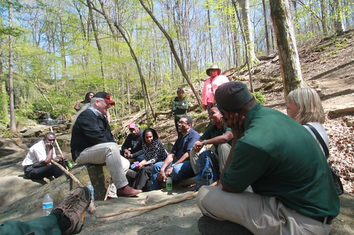 Deputy Under Secretary Butch Blazer with Greening Youth Foundation members near a waterfall