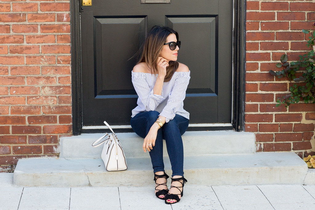 off the shoulder top with dark denim and fringe shoes for a summer outfit in new york city 