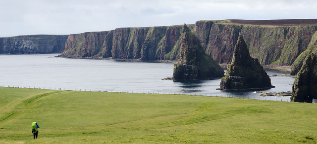 Woman with a baby looks at Duncansby Stacks, Caithness, Scotland.