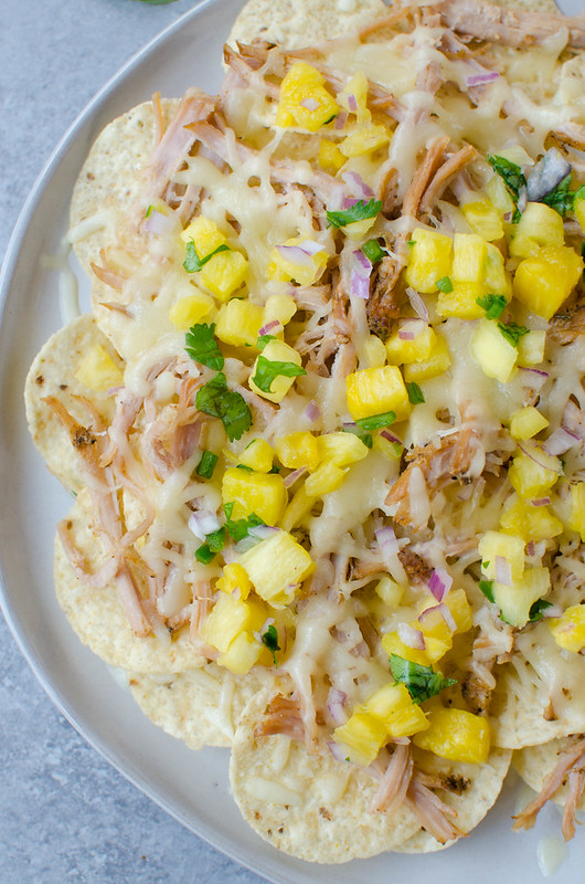 Pulled Pork Nachos with Pineapple Salsa - simple slow cooked pork piled on tortilla chips with monterey jack cheese and a quick and easy homemade pineapple salsa! 