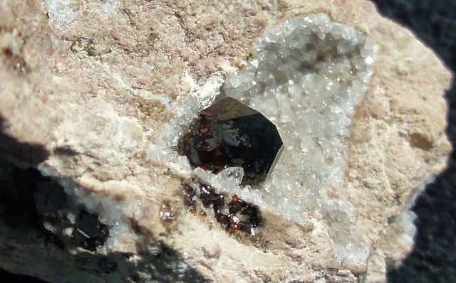 Side view of same garnet from above. A second garnet is nestled in the rhyolite on the bottom left side.